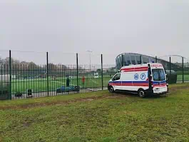 Ambulans przystosowany do przewozu osób niepełnosprawnych na zielonym boisku.