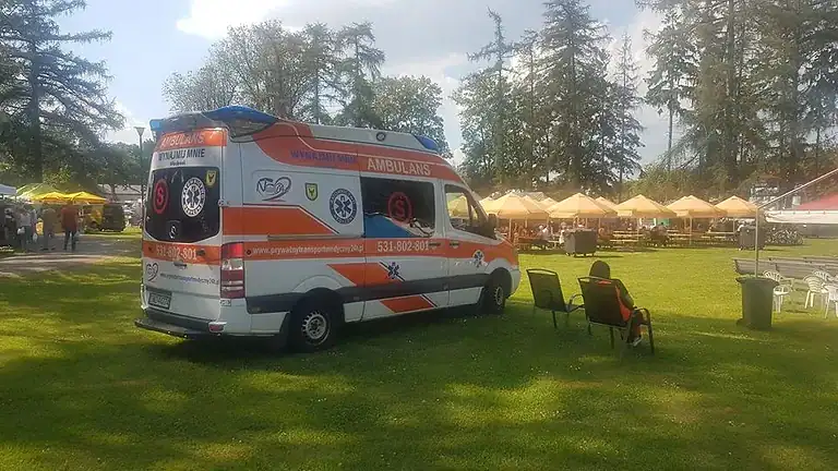 Ambulans do przewozu osób niepełnosprawnych na imprezie plenerowej, specjalistyczny transport medyczny, komfortowy i bezpieczny przewóz niepełnosprawnych, profesjonalna opieka medyczna, szybki dojazd na wydarzenie.